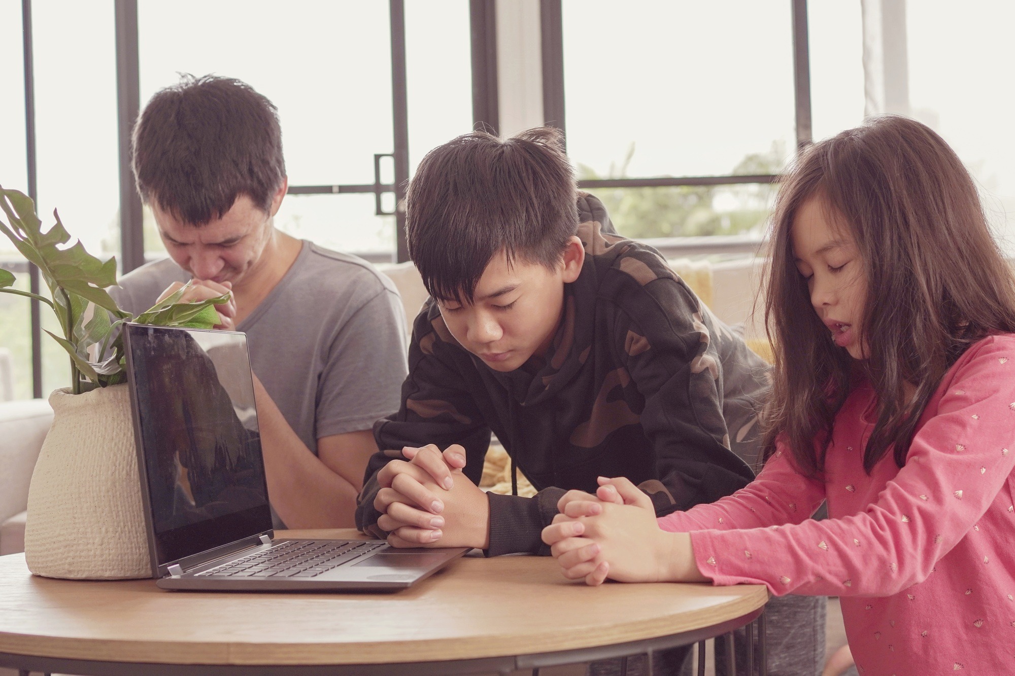 Children praying with father, family and kids fellowship worshiping online at home